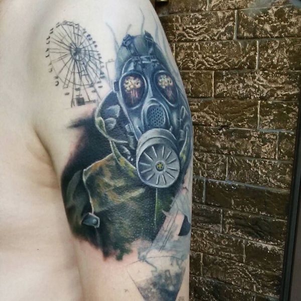 Tatouage coloré d'un harceleur avec un masque à gaz sur l'épaule.