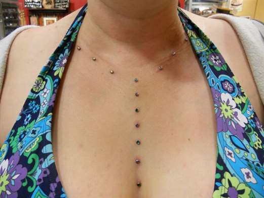 Ce piercing ressemble à un piercing traversant, mais il s'agit en réalité de deux boucles d'oreilles différentes.