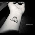 Tatouage des reliques de la mort sur le poignet