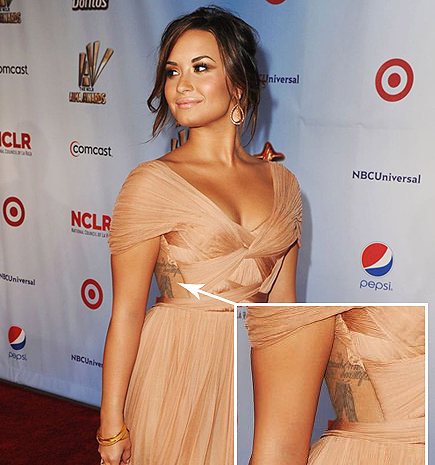 La démo de Lovato avec des tatouages sur le côté de son torse