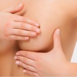 la fille couvre ses tétons avec la paume de sa main.