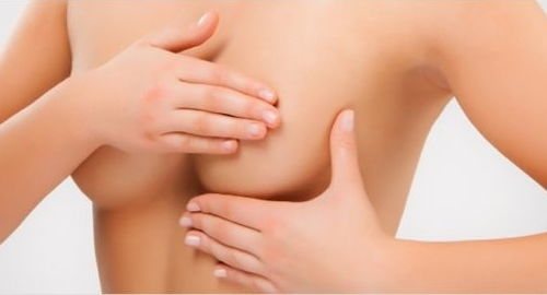Une fille couvre ses tétons avec la paume de sa main.