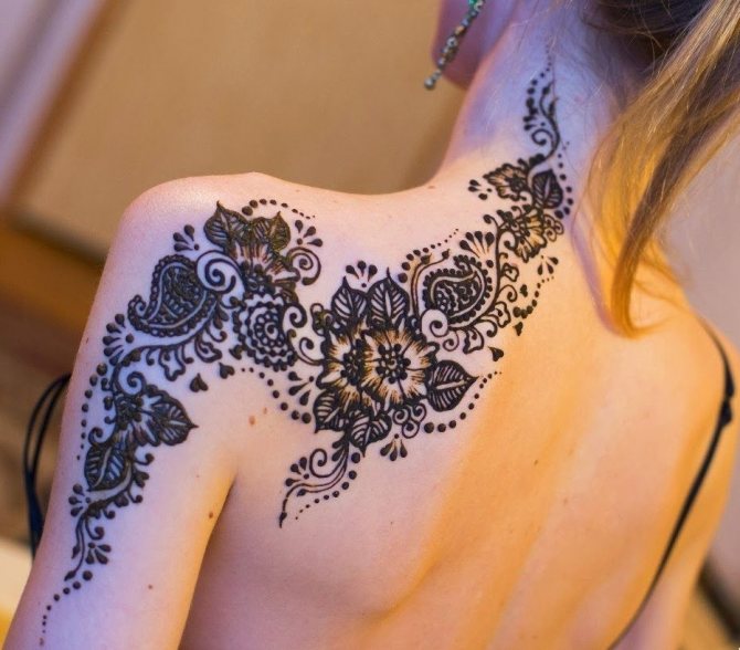 Tatouage d'une fleur élégante affectant l'épaule, l'omoplate, le cou