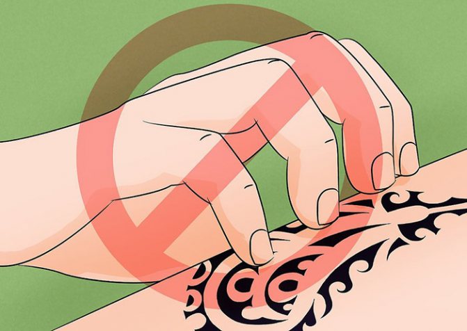 Alors que la croûte descend sur le tatouage. Guérison du tatouage par jours, photo