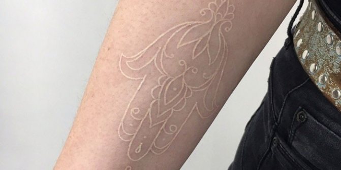 Tatouage blanc de contour sur le bras