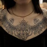 Magnifique tatouage de col en dentelle avec des cœurs et des roses symbolisant l'amour et la passion.