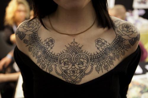 Magnifique tatouage de col en dentelle avec des cœurs et des roses symbolisant l'amour et la passion.