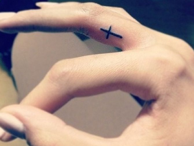 Tatouage d'une croix sur un doigt - la marque d'un voleur