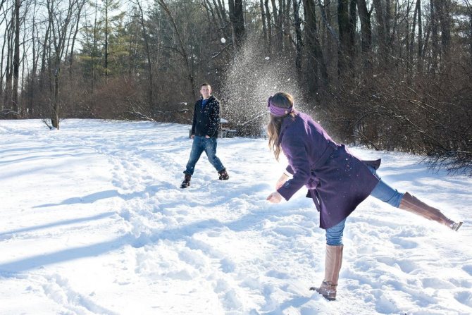 Homme et femme jouant aux boules de neige
