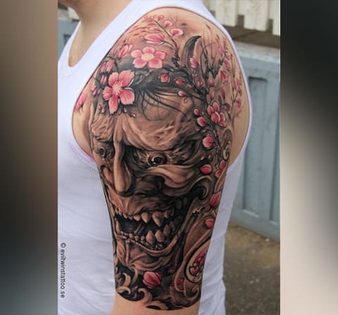 Tatouage masculin d'une cerise sur l'épaule