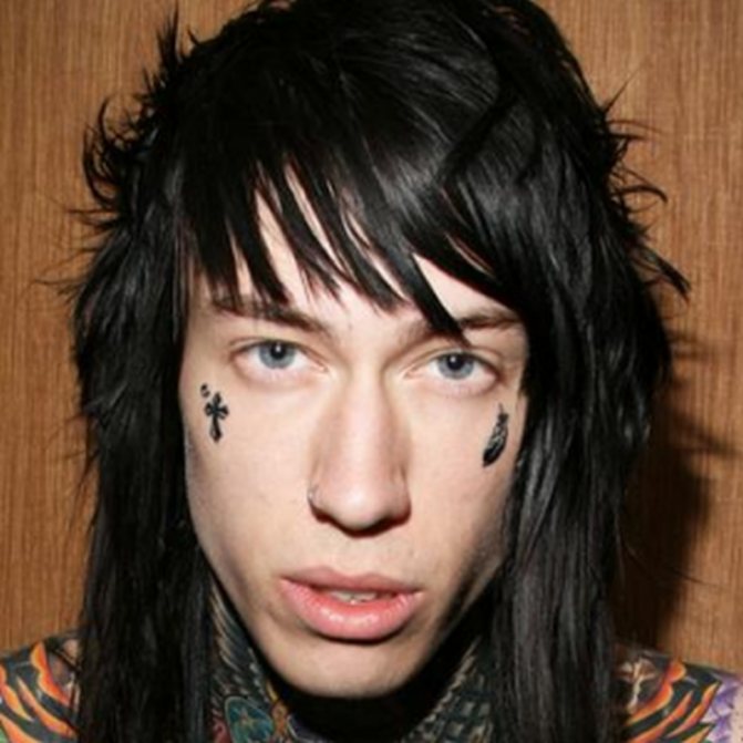 Tatouage de croix et plumes sur visage masculin