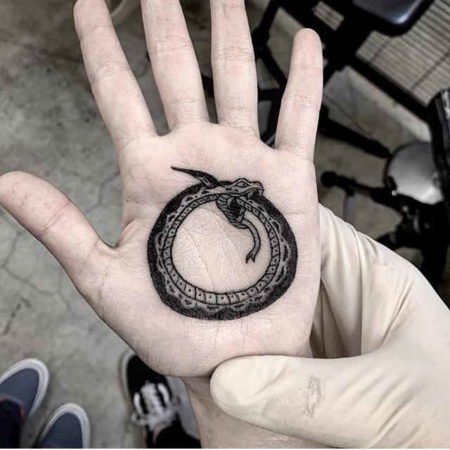 Sur les paumes des tatouages Ouroboros