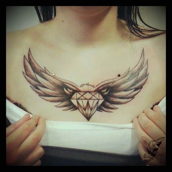 Tatouage d'un diamant et d'ailes sur la poitrine