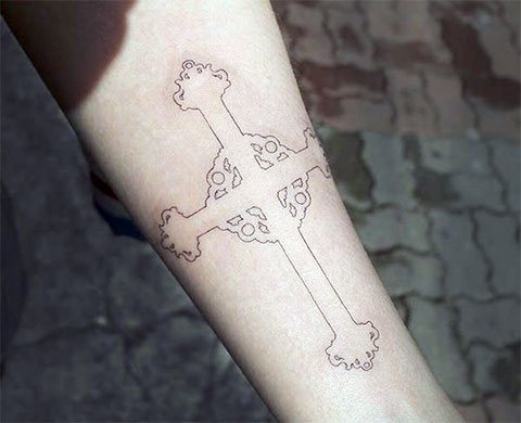 Tatouage d'une croix noire sur le bras gauche