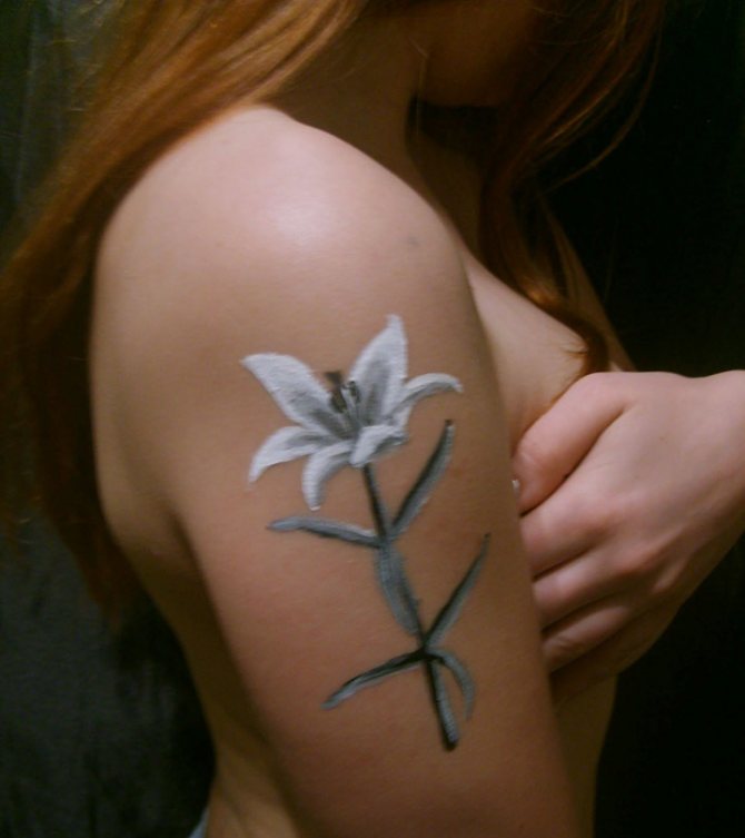 Tatouage d'une fleur de lys sur l'épaule d'une femme