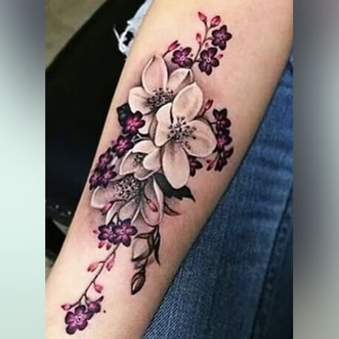 Tatouage de fleurs de cerisier sur le bras d'une fille