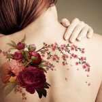 Tatouage de fleurs. Croquis en noir et blanc, colorés sur le bras, la clavicule, la jambe, la cuisse.