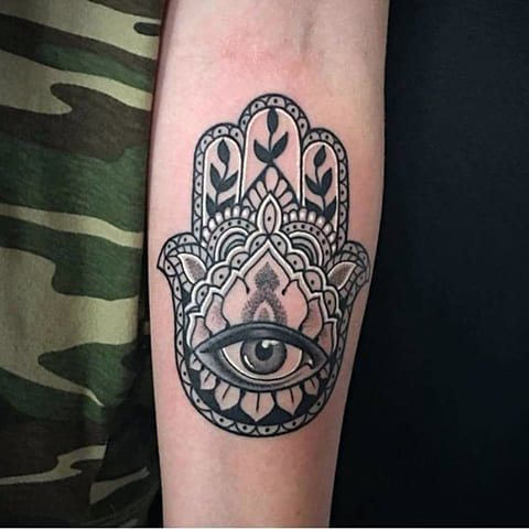 Tatouage d'un hamsa avec un œil sur son bras
