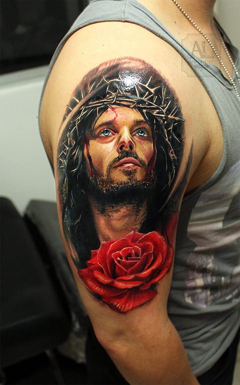 Tatouage de Jésus-Christ avec une couronne d'épines et une rose sur son bras