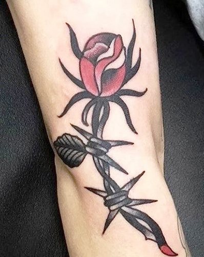 Tatouage de fil barbelé. Signification sur pied, poignet, cou, jambe, avec fleurs, rose, cœur, croix
