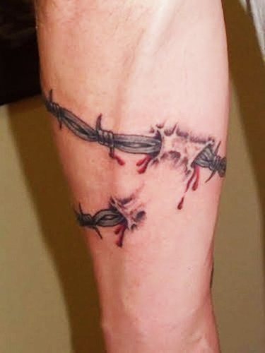 Tatouage de fil barbelé. Signification sur pied, poignet, cou, jambe, avec fleurs, rose, cœur, croix