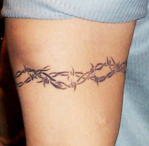Tatouage de fil barbelé. Signification sur pied, poignet, cou, jambe, avec fleurs, rose, cœur, croix
