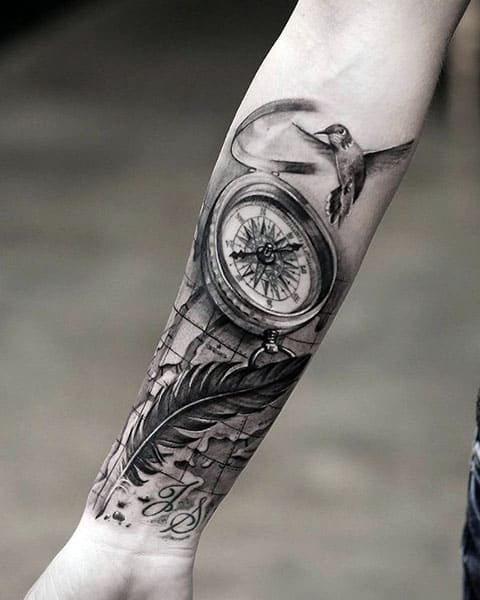 Tatouage d'un compas et d'un oiseau en plumes à la main