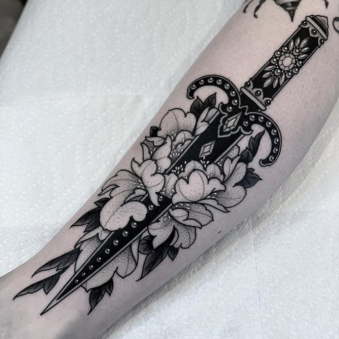 Tatouage poignard court avec fleurs sur l'avant-bras