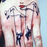 Marionnettiste et marionnette tatoués sur les mains