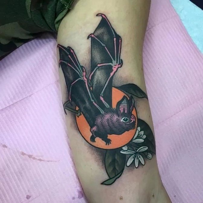 Tatouage de chauve-souris avec fleurs sur les biceps