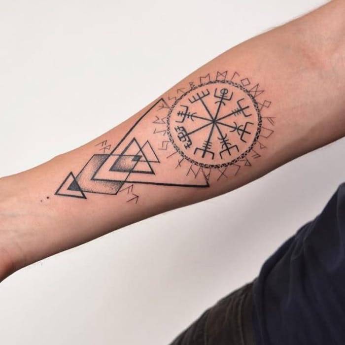 Tatouage d'un mandala avec des runes sur l'avant-bras