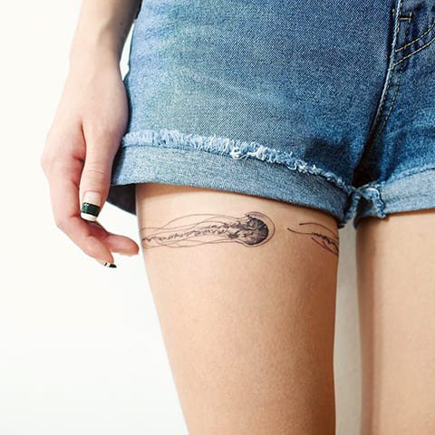 Tatouage d'une méduse sur la cuisse d'une fille