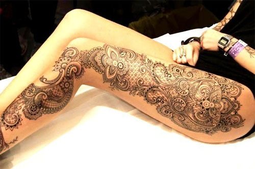 Tatouage sur le dos d'une fille, photo. Beaux motifs, dentelle, fleurs, croquis, inscriptions avec traduction