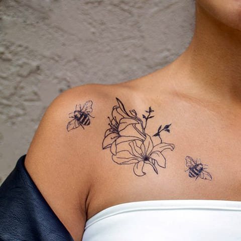 Tatouage abeille et fleur sur la clavicule