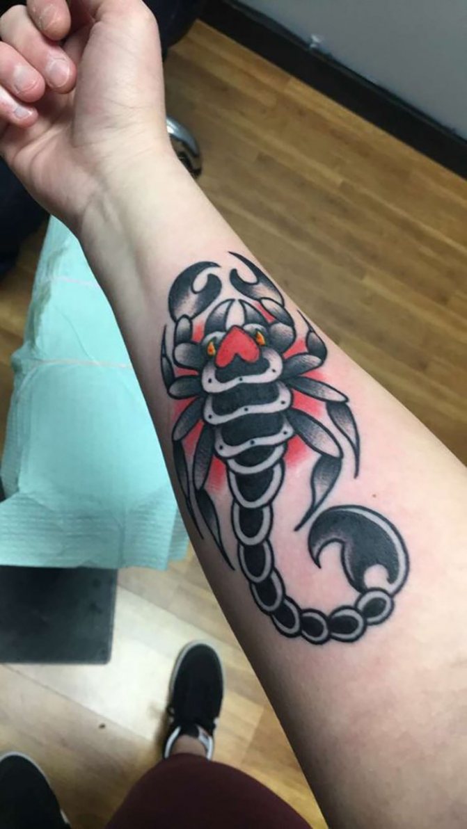 Tatouage de scorpion sur l'avant-bras avec un cercle rouge