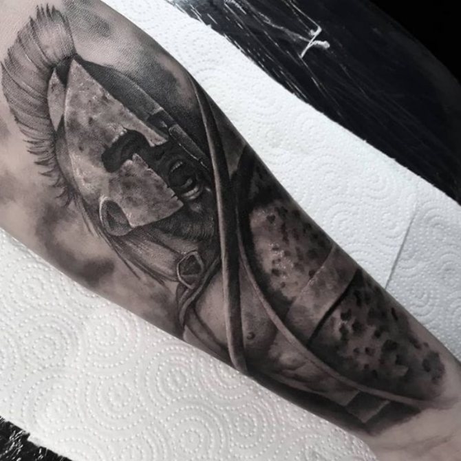 tatouage sur le bras d'un spartiate
