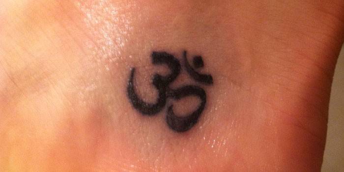 Tatouage sur la cheville d'une fille : le symbole de Om