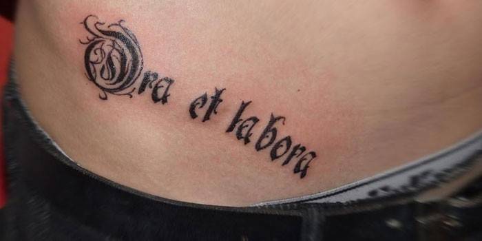 Tatouage sur le ventre d'une fille : Prier et travailler