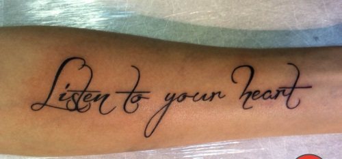 Inscriptions de tatouage sur le bras d'une fille. Photo, croquis en latin avec traduction, signification