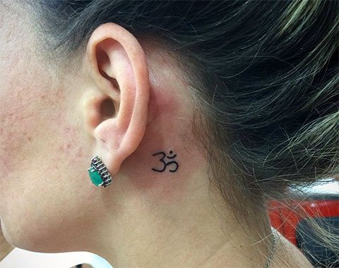 Tatouage Eom derrière l'oreille d'une fille