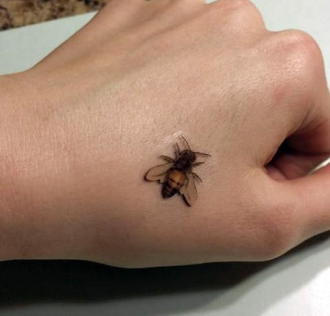 Tatouage d'une abeille sur le poignet