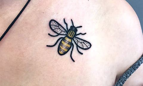Tatouage abeille sur la clavicule