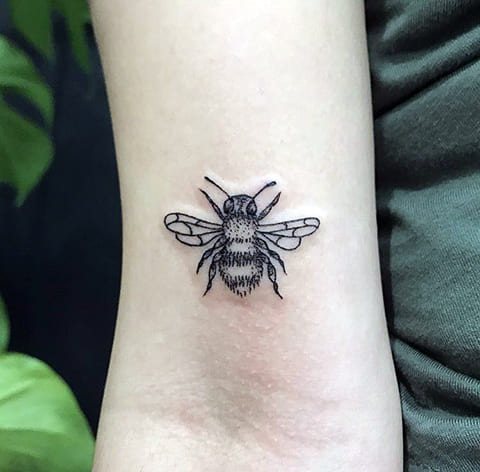 Tatouage d'une abeille sur le bras