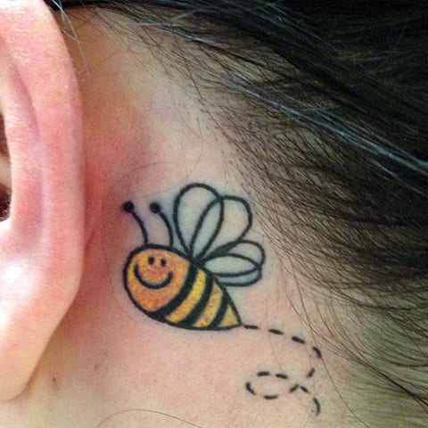 Tatouage d'une abeille derrière l'oreille