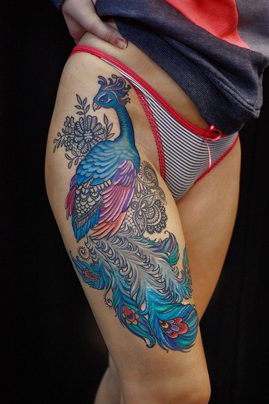 Tatouage d'une plume - signification pour une fille avec un mot, des oiseaux, un paon sur une jambe, un bras, un poignet, le ventre, le cou, le dos, la clavicule, sur le côté.