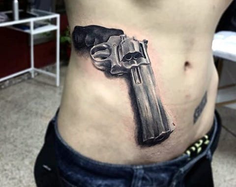 Tatouage d'un pistolet sur le côté d'un homme