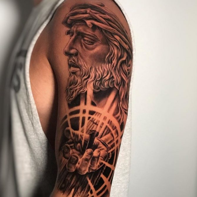 tatouage de la crucifixion du Christ sur son bras