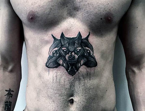 Tête de cerbère tatouée sur le ventre d'un homme - photo