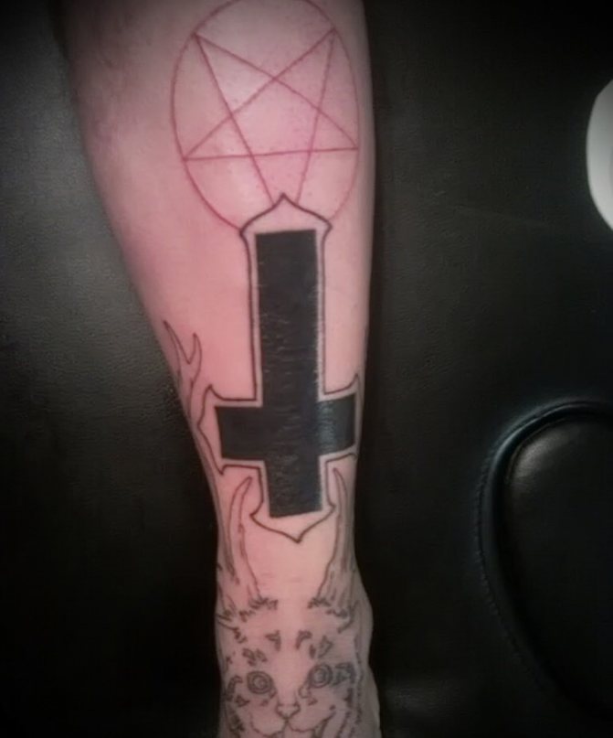 Tattoo avec une croix inversée.
