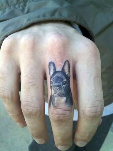 Tatouage d'un chien sur un doigt